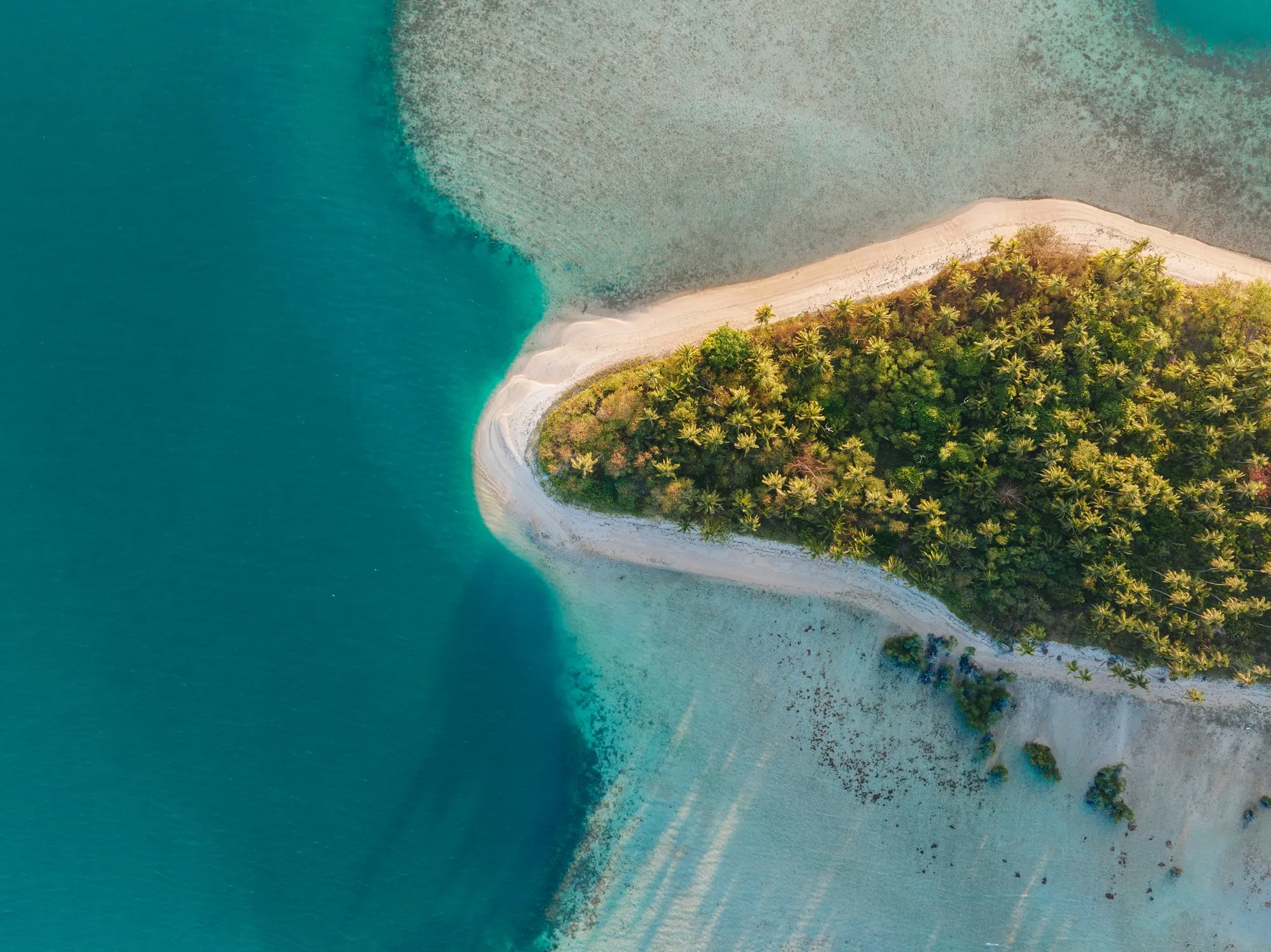 Aerial view of a private tropical island surrounded by turquoise water
